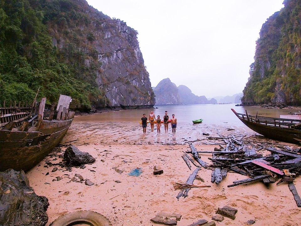 Small group standing in a coastal valley surrounded by rocks.