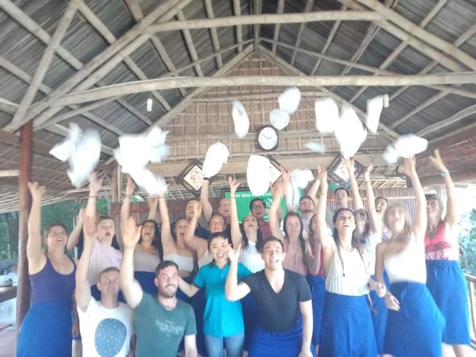 Group celebrating under a pavilion by throwing papers.