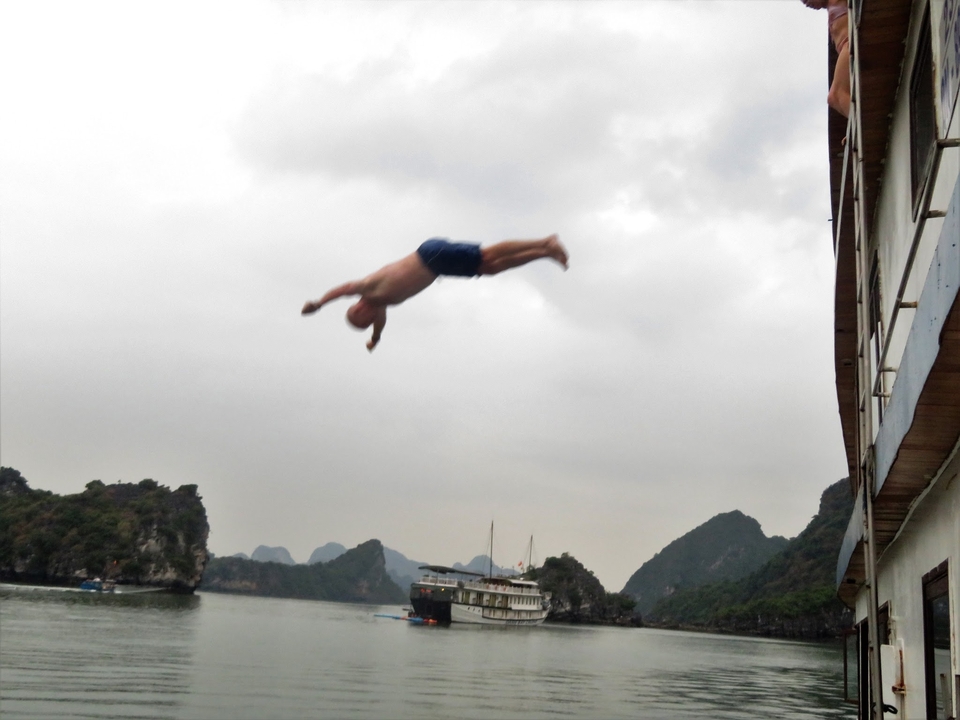 Person diving off a boat into the water.