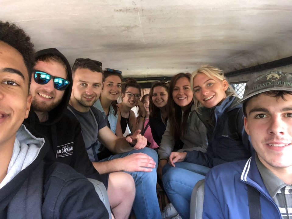 A group of friends smiling inside a vehicle.