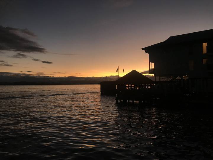 A beautiful sunset over water with silhouettes of buildings.