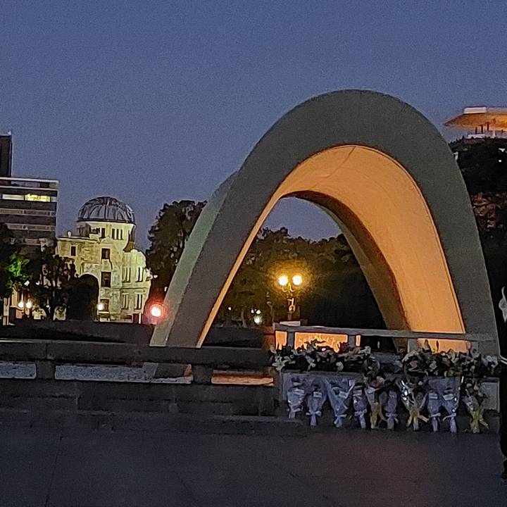 Crowded area with an outdoor structure at night.