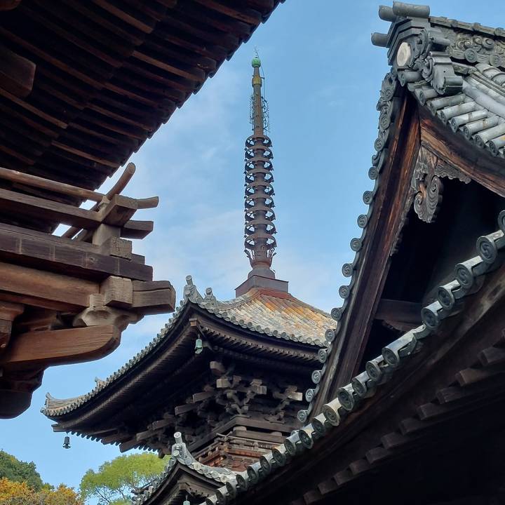 Pagoda spire surrounded by temple roof architecture.