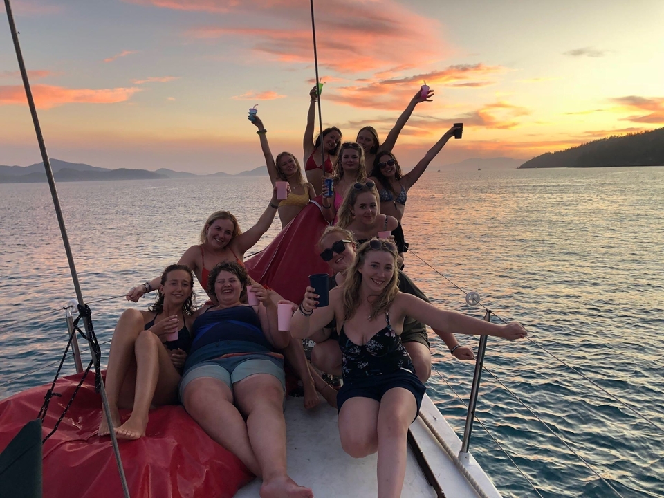 Group celebrating on a boat during sunset