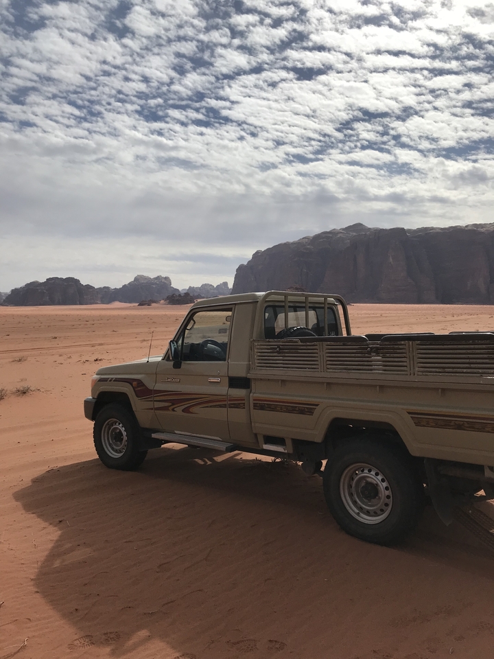 Desert landscape with a 4x4 vehicle at Wadi Rum.