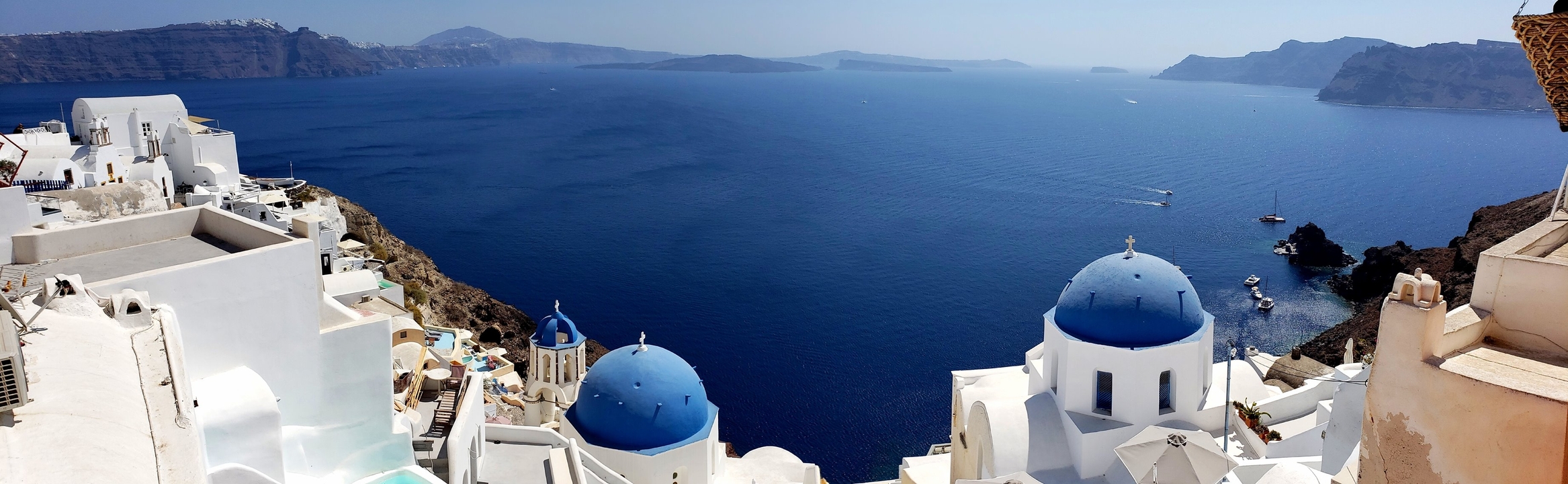 View of the blue sea and iconic blue-domed buildings.