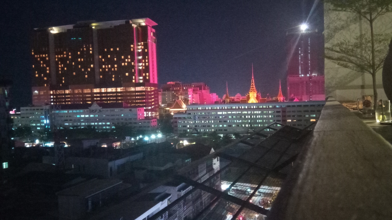 Night view of a city skyline with illuminated buildings.