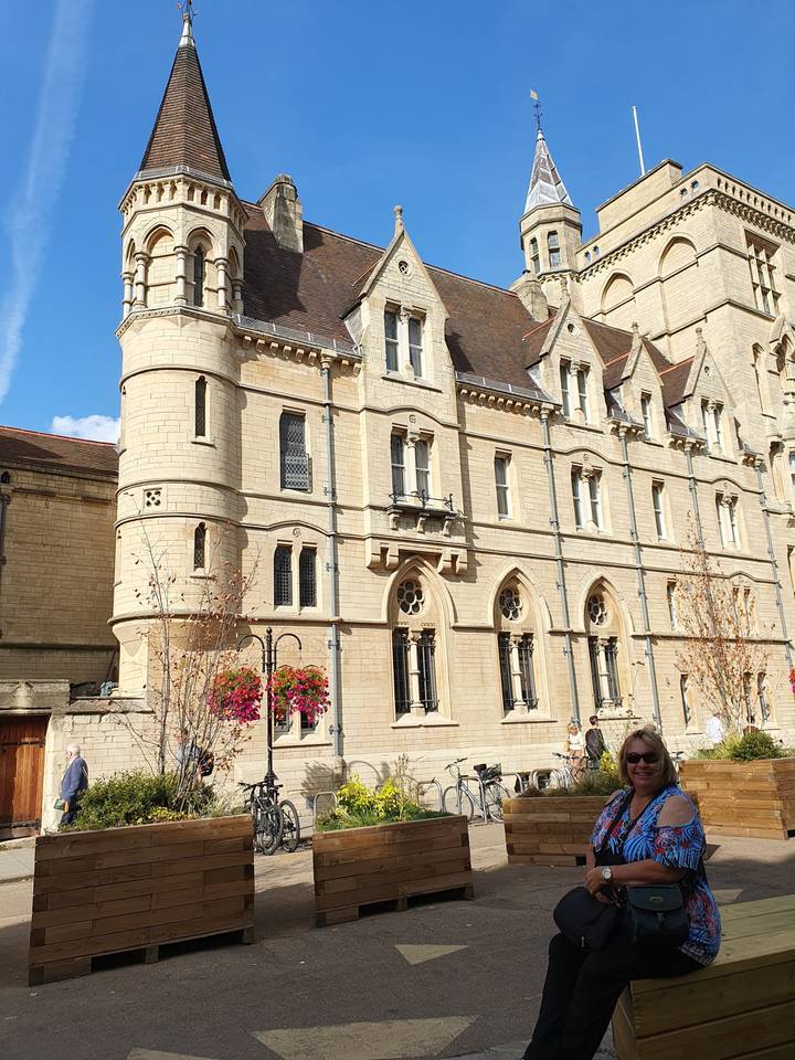 Historic building with decorative elements, with a person posing.