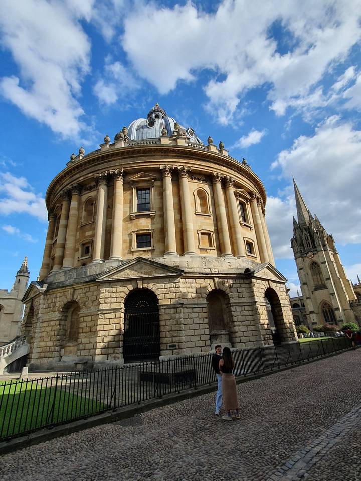 Historic round building with dome structure, person posing.