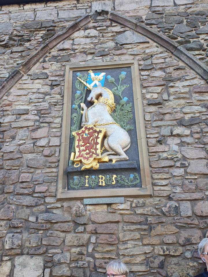 Decorative stone plaque with symbols and inscriptions on a wall.