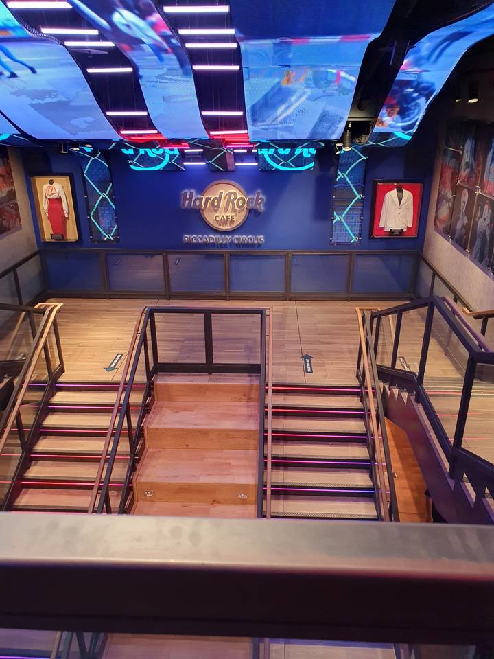 Interior decor of a Hard Rock Cafe with colorful lighting and decorations.