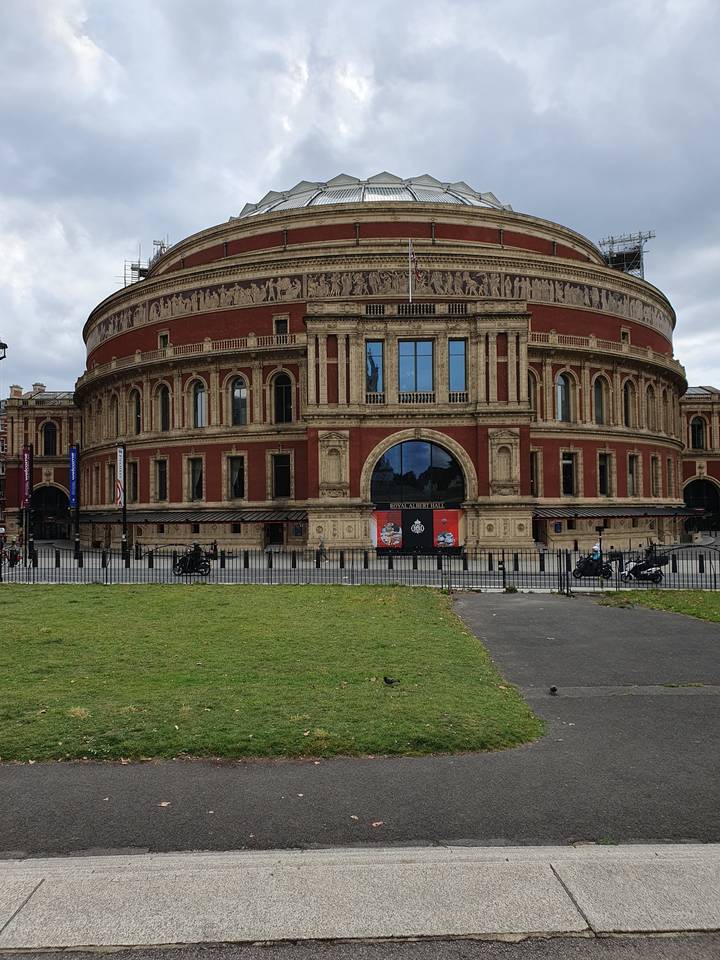 Iconic concert hall building with a dome structure, in park setting.