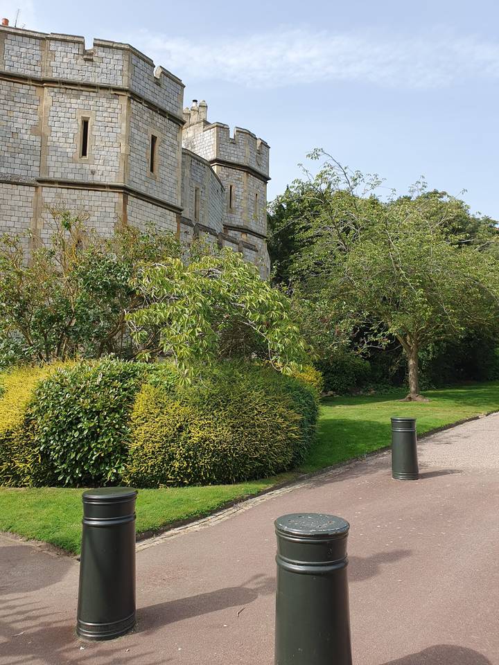 Stone castle with gardens in the foreground.