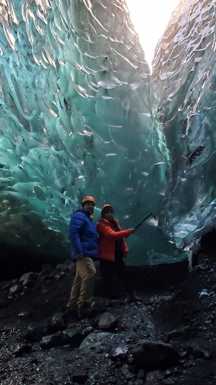 Two people exploring an ice cave.