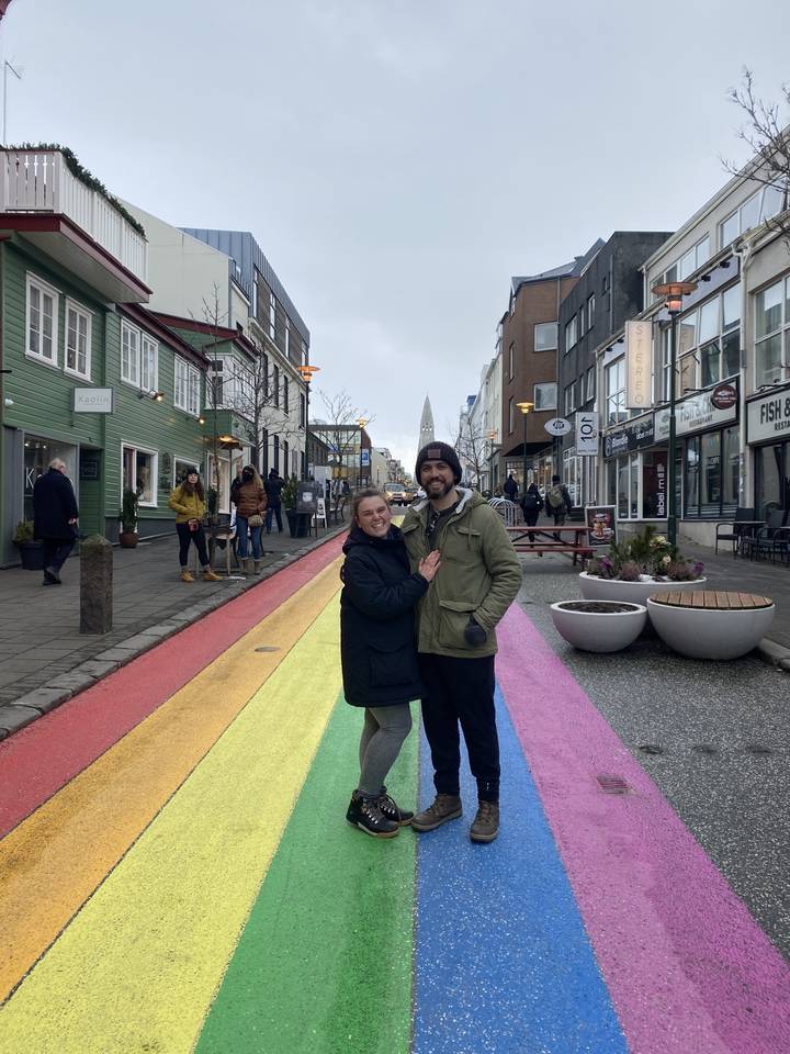 Two people posing on a colorful street