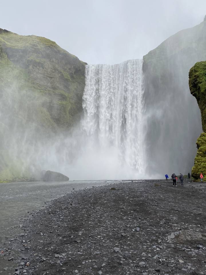 Large waterfall cascading over rocks with mist surrounding the base.