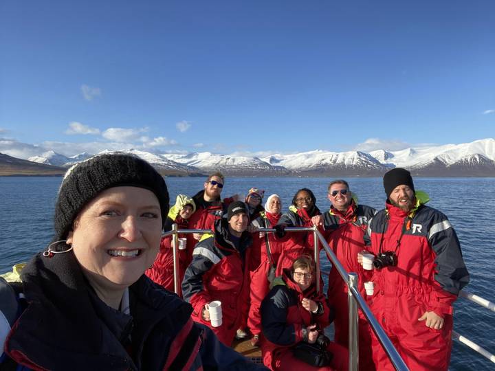 Group of people in red jackets on a boat.