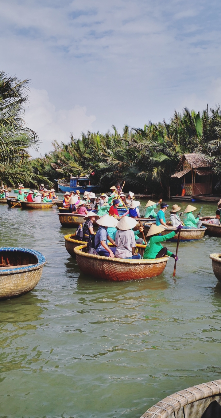 People rowing traditional basket boats in a river.
