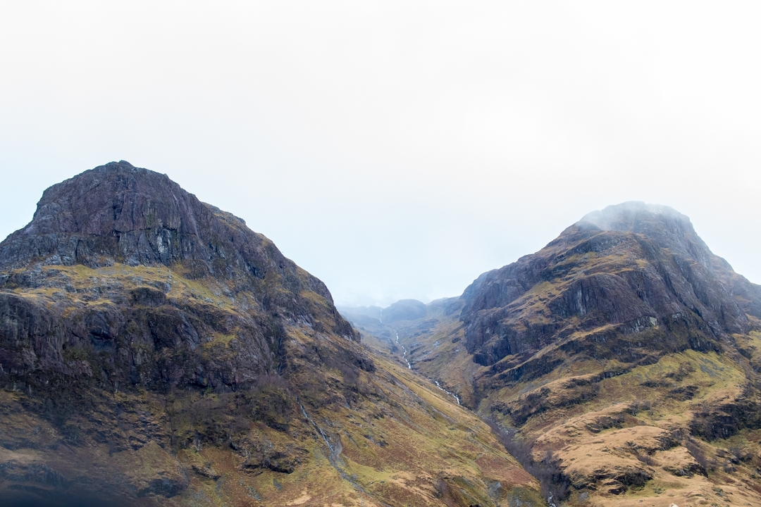 Dramatic mountain peaks with mist between them.