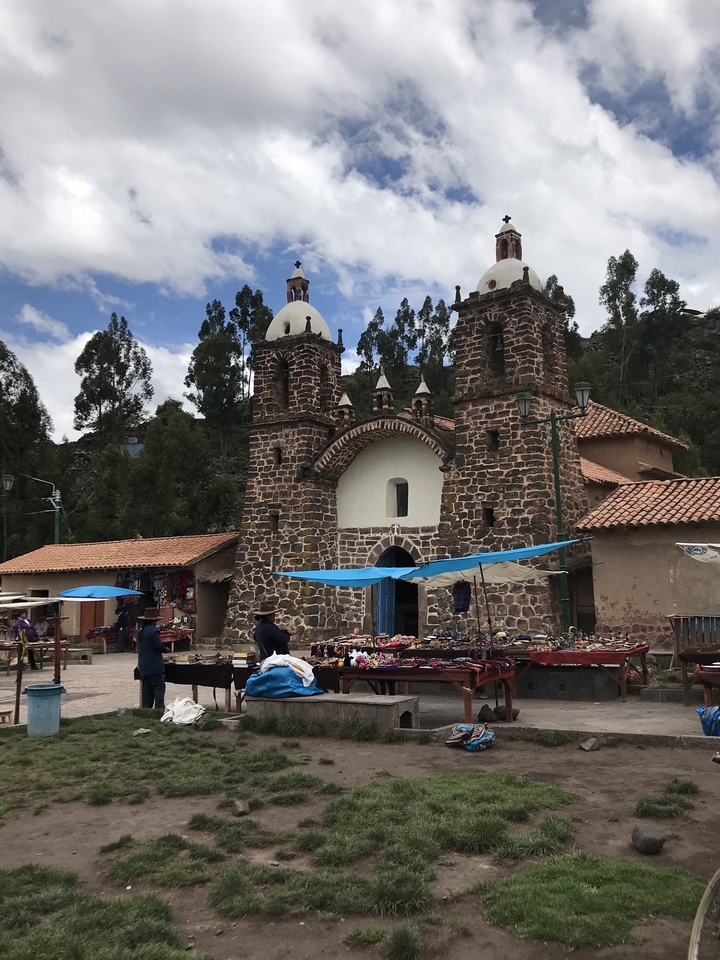 A market scene in front of a rustic church.