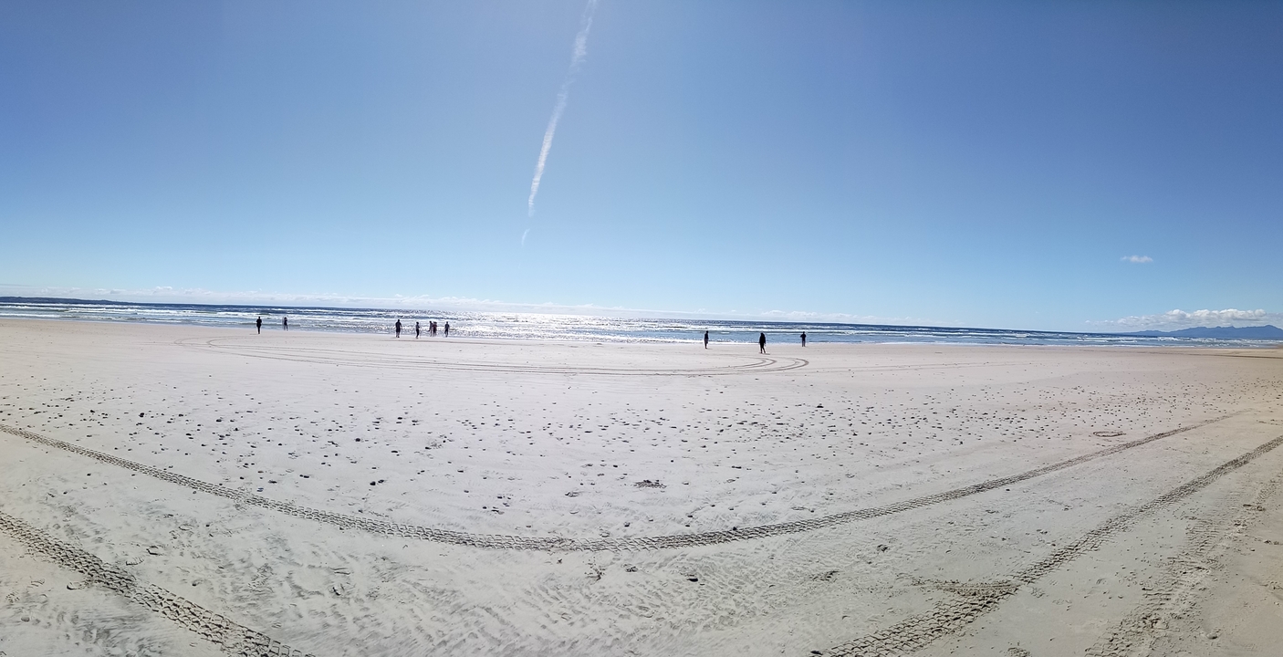 Panoramic view of a beach with distant people.