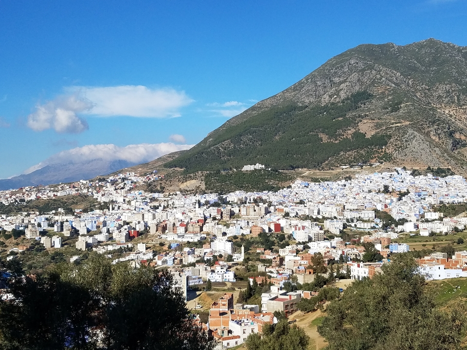 Panoramic view of Chefchaouen with a mountainous backdrop.