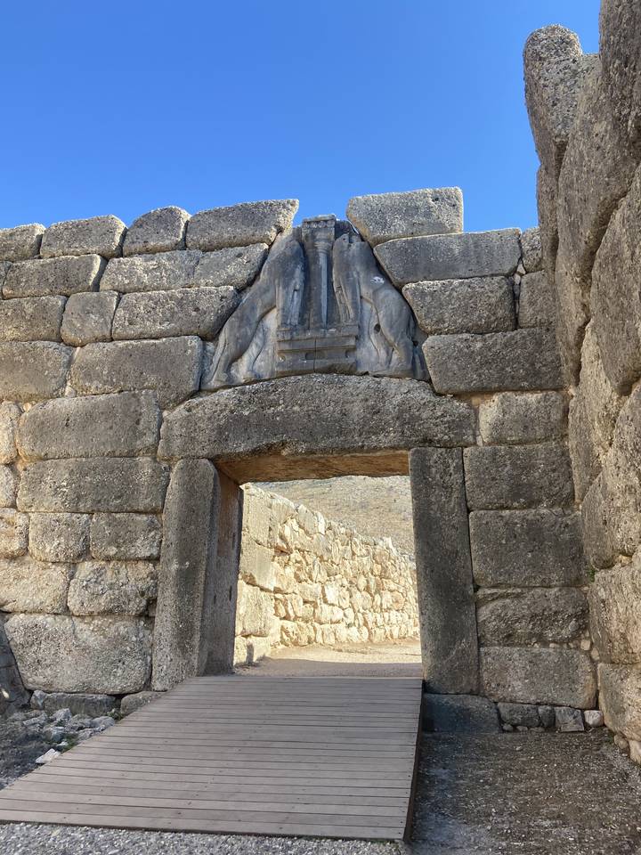 Porte de pierre archaïque avec un relief sculpté au-dessus.