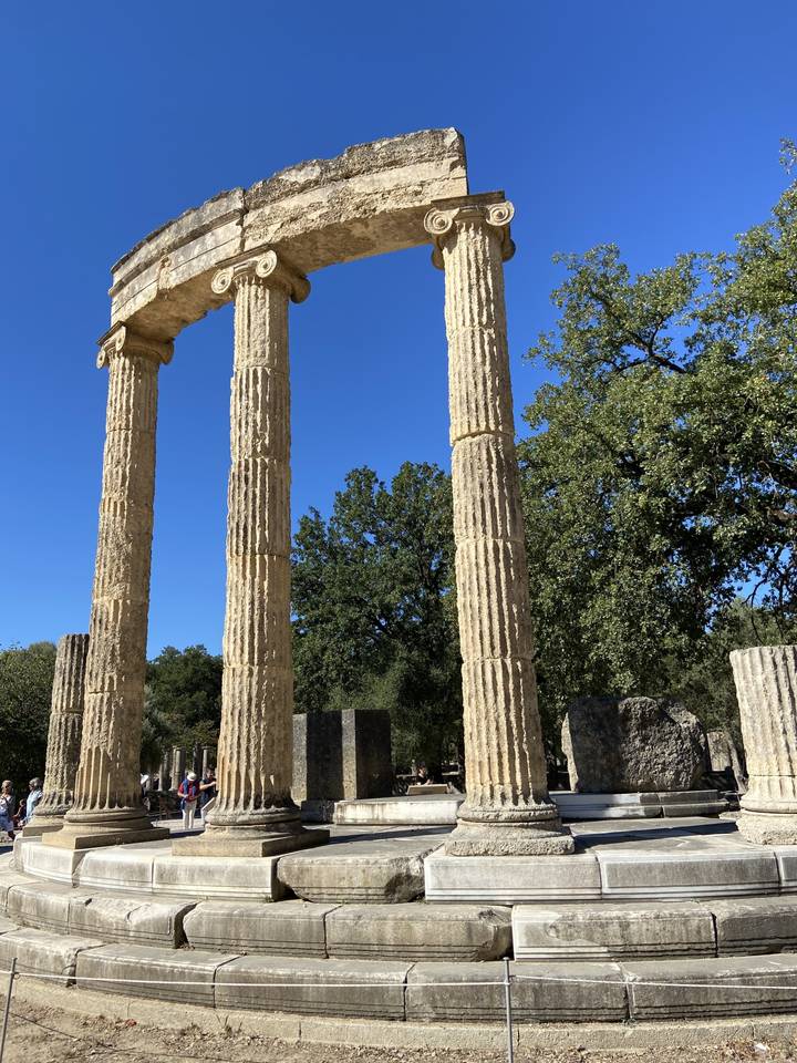 Ruines de colonnes et structures antiques avec un ciel bleu.