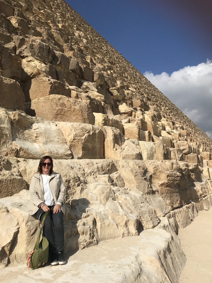 Person standing in front of the pyramids in Egypt.