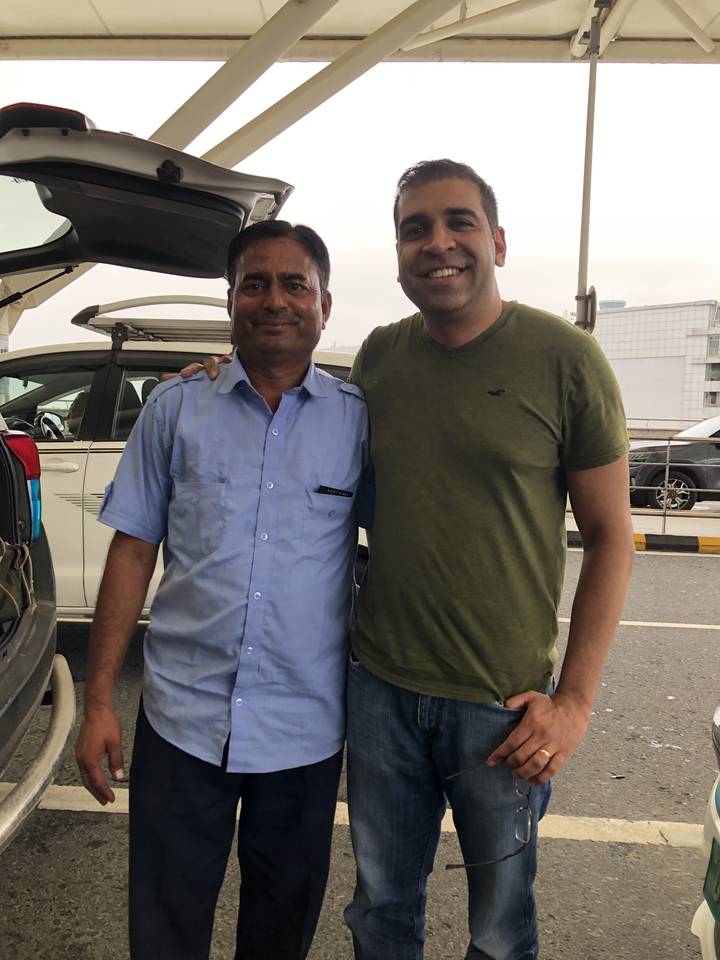 Two men posing together outdoors, smiling.