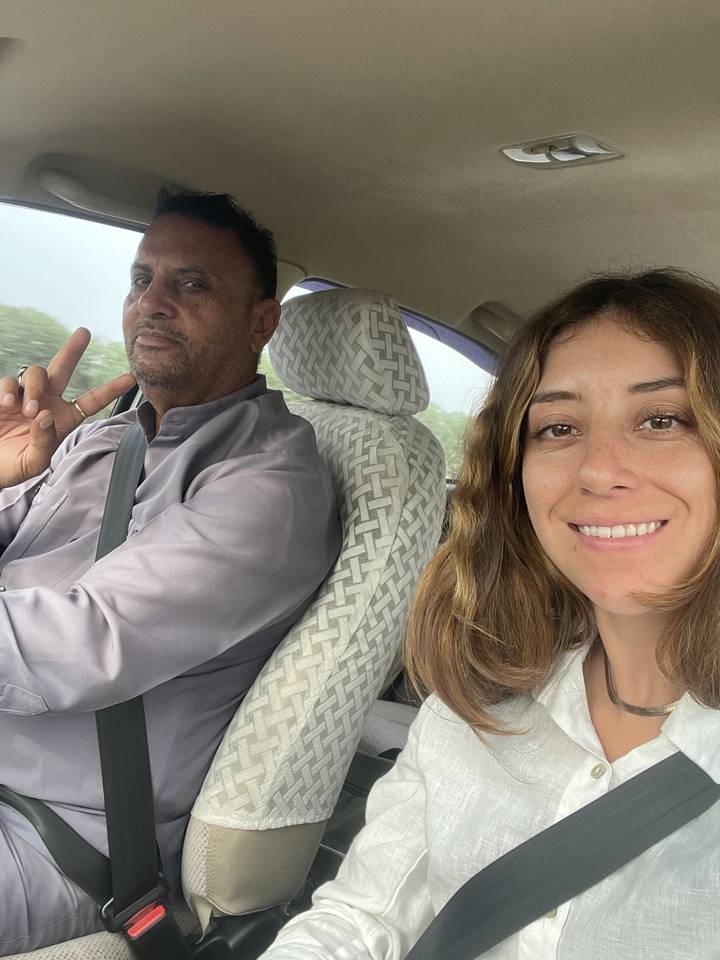 Two people sitting in a car, one wearing a seatbelt.