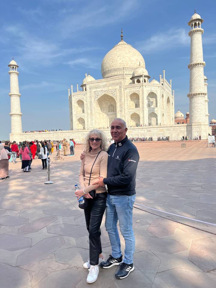 Couple posing in front of the Taj Mahal.