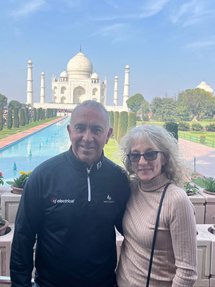 Couple posing with the Taj Mahal in the background.