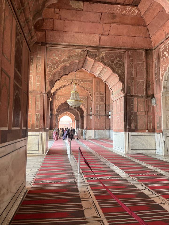 An interior corridor with intricate designs on walls.