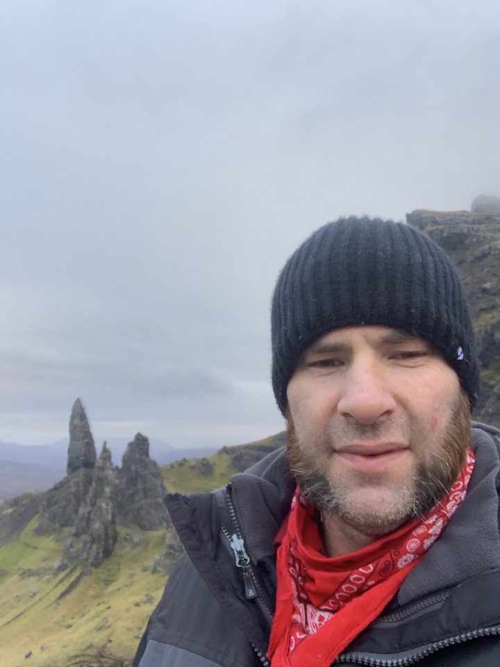 Person taking a selfie in a mountainous landscape.
