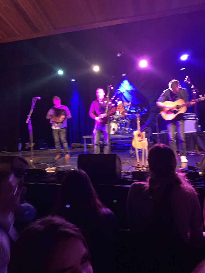 Blurry image of musicians performing on stage.