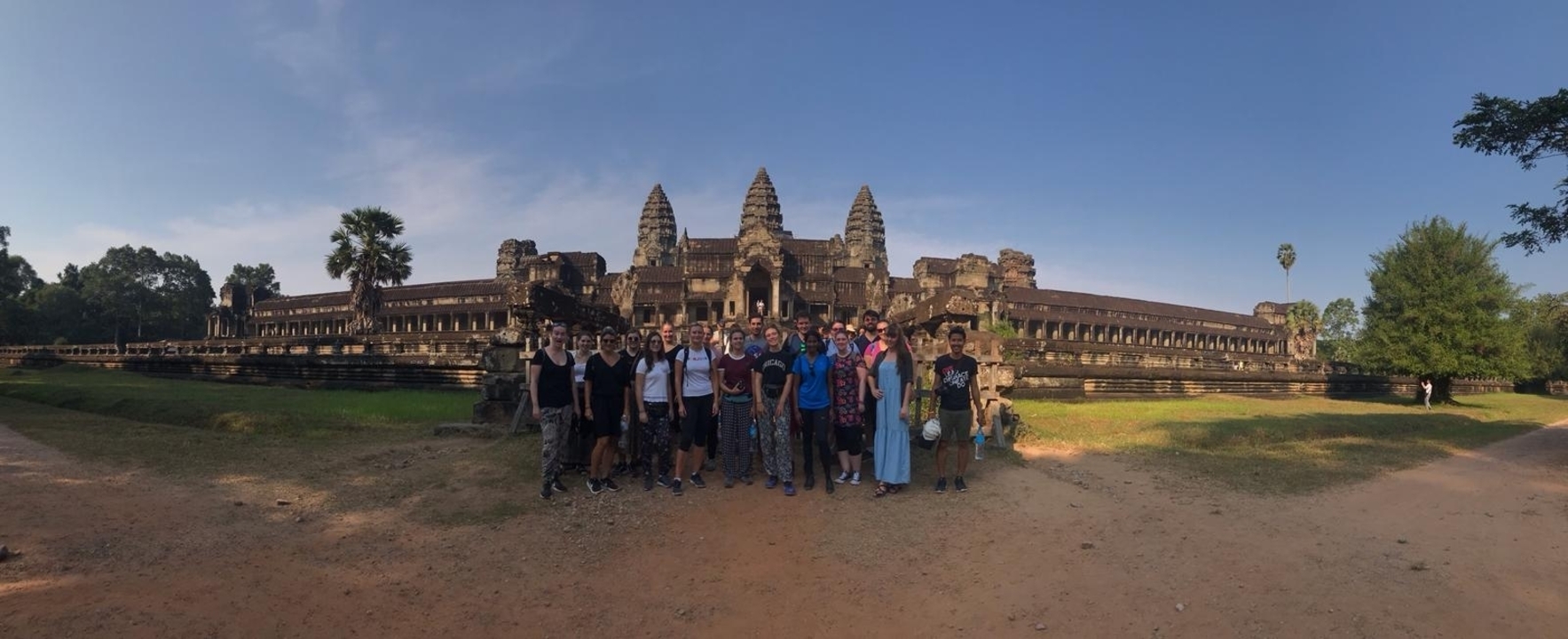 Groupe de touristes posant devant un grand temple antique.