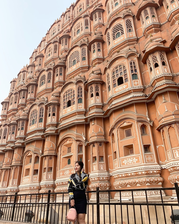 Architectural detail of the pink sandstone Hawa Mahal with its ornate windows.