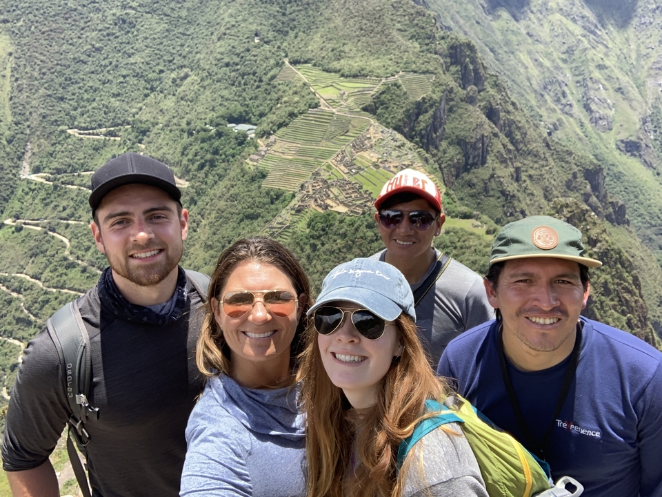 Group photo with a panoramic view of Machu Picchu in the background.