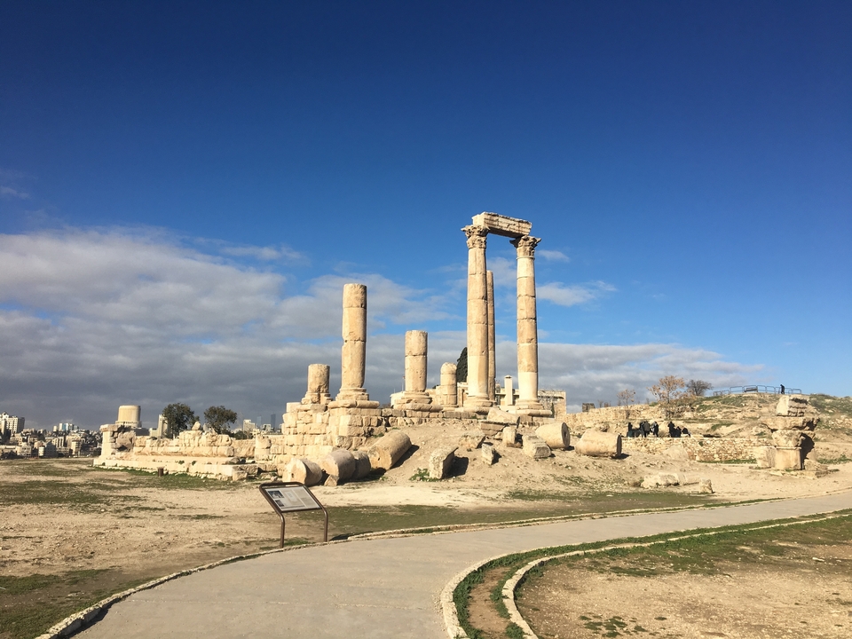 Ruines architecturales anciennes avec des colonnes sous un ciel bleu.