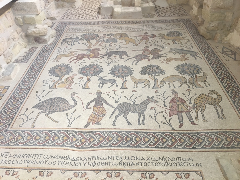 Mosaïque antique colorée représentant divers animaux et arbres.