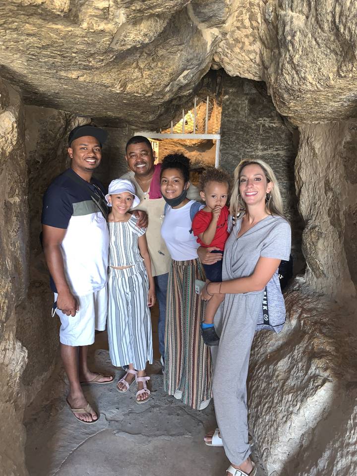 Family posing inside a rocky area.