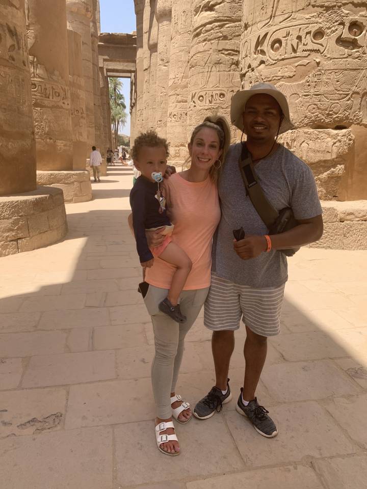 Family posing in front of hieroglyphic-covered walls.