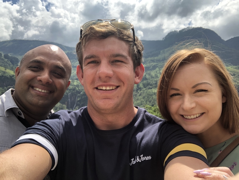 Selfie de groupe avec des montagnes boisées en arrière-plan.