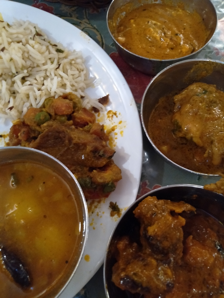 Close-up of various Indian dishes served in metal bowls.