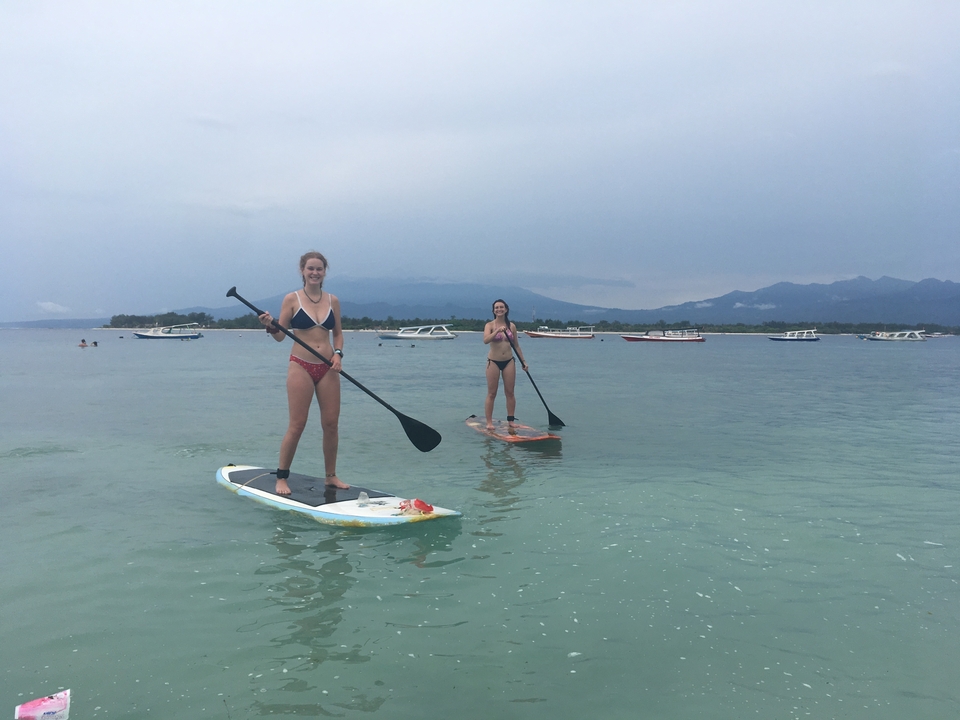 Two people paddleboarding on calm water.