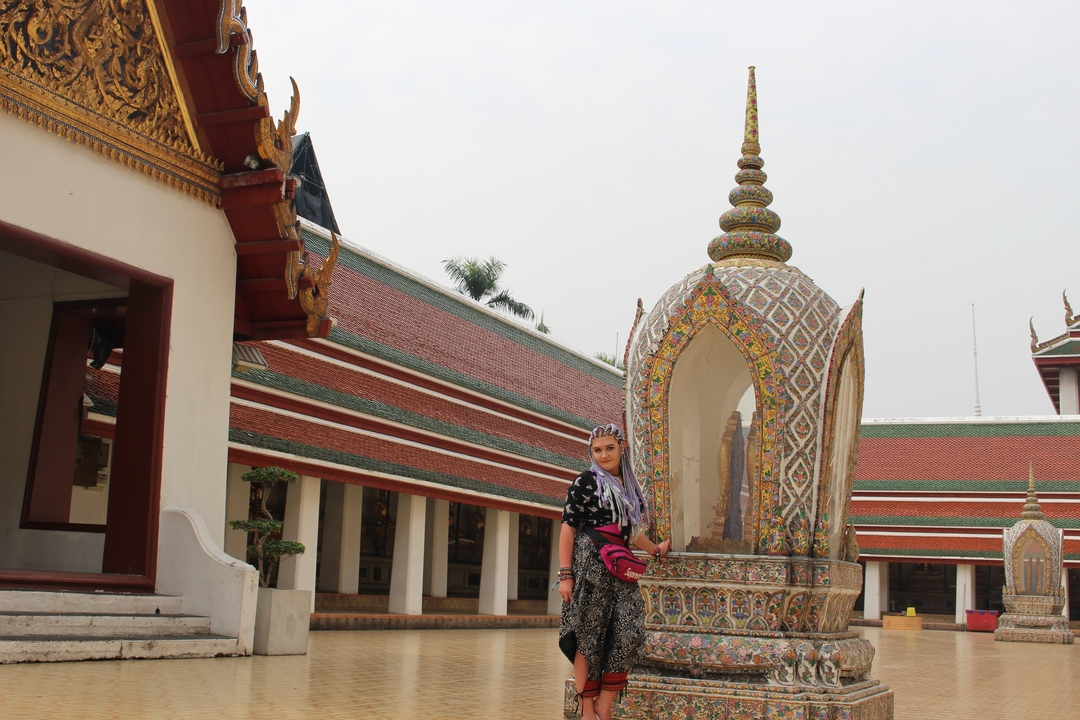 Person standing near a temple with spires.