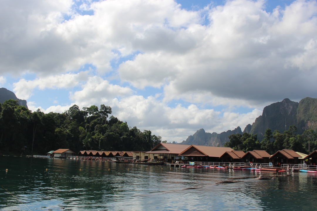 Scenic view of houses on a lake surrounded by mountains.
