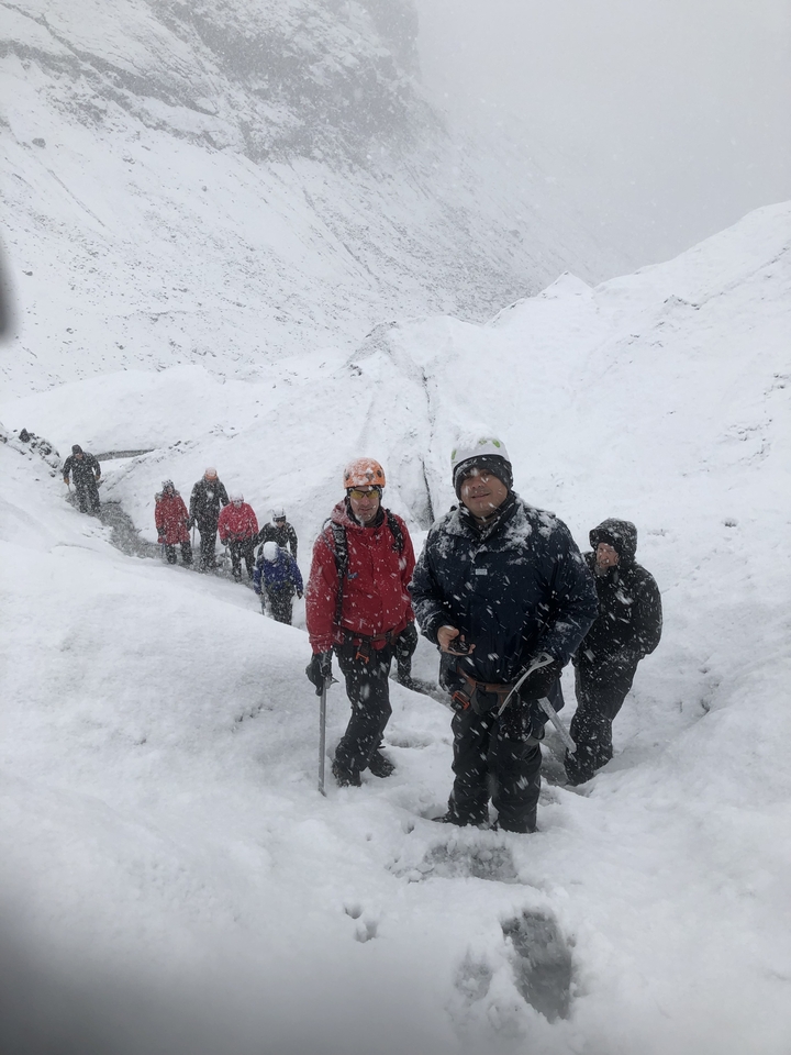 Group of people in snowy attire on a mountain.