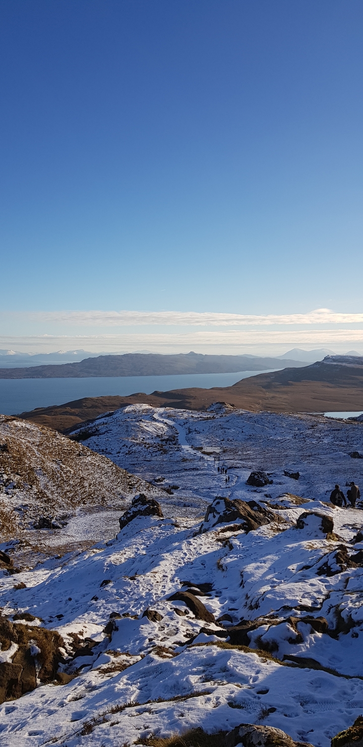 Snow-covered landscape with distant waters.